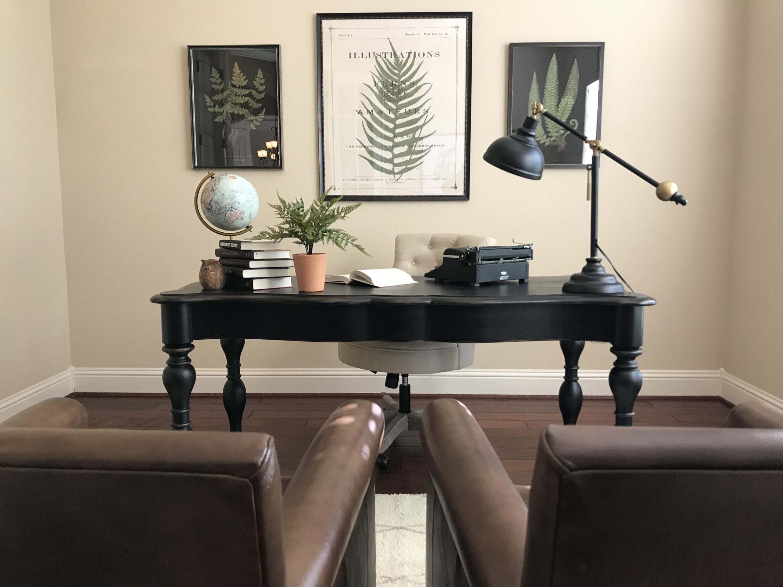 Home staging example of a home office with two leather chairs facing a desk.
