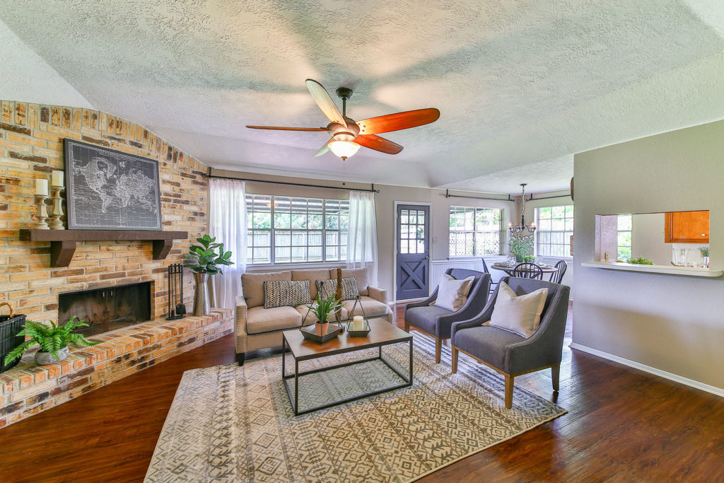 Home staging example of a living room with a rustic, brick fireplace.